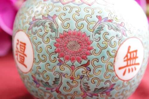 A beautiful and detailed jade-green oriental ginger jar & lid with hand painted symbols and flowers