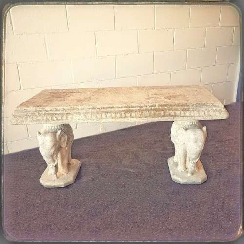 A gorgeous solid concrete outdoor garden bench with beautifully detailed "elephant" leg supports