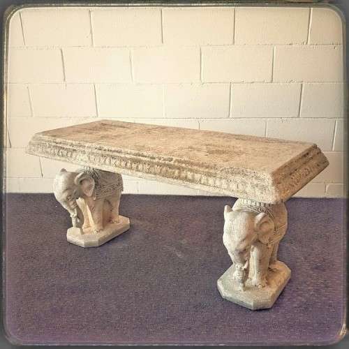 A gorgeous solid concrete outdoor garden bench with beautifully detailed "elephant" leg supports