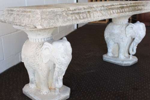A gorgeous solid concrete outdoor garden bench with beautifully detailed "elephant" leg supports