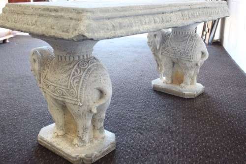A gorgeous solid concrete outdoor garden bench with beautifully detailed "elephant" leg supports
