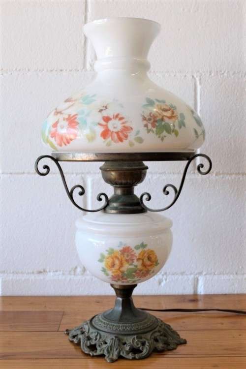 A stunning vintage milk-glass table lamp with floral transfer work on a brass tone metal base