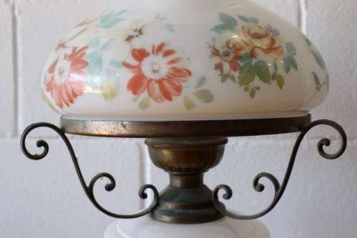 A stunning vintage milk-glass table lamp with floral transfer work on a brass tone metal base