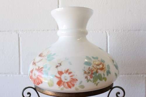 A stunning vintage milk-glass table lamp with floral transfer work on a brass tone metal base