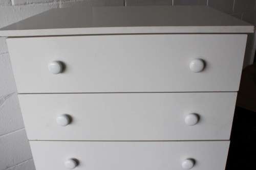 A lovely white veneer 5-drawer chest of drawers in good condition - perfect for extra packing space