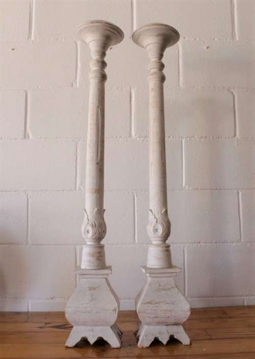 A pair of tall white chalk-painted carved wooden candle stands - perfect ambience lighting