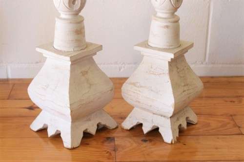 A pair of tall white chalk-painted carved wooden candle stands - perfect ambience lighting