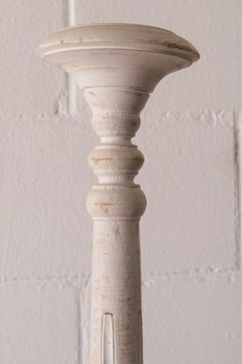 A pair of tall white chalk-painted carved wooden candle stands - perfect ambience lighting