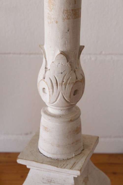 A pair of tall white chalk-painted carved wooden candle stands - perfect ambience lighting