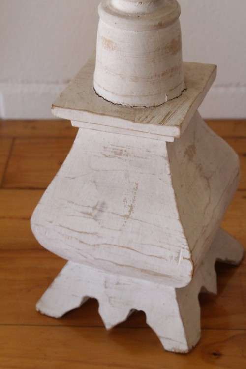 A pair of tall white chalk-painted carved wooden candle stands - perfect ambience lighting