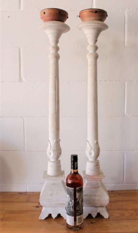 A pair of tall white chalk-painted carved wooden candle stands - perfect ambience lighting