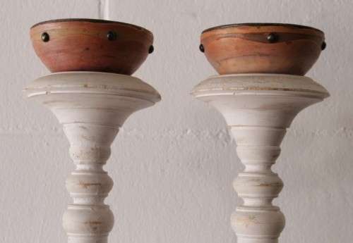 A pair of tall white chalk-painted carved wooden candle stands - perfect ambience lighting