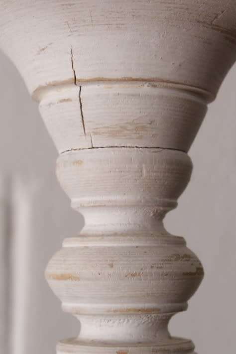 A pair of tall white chalk-painted carved wooden candle stands - perfect ambience lighting