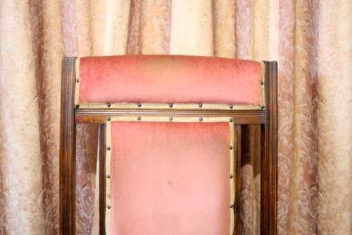 A lovely vintage Imbuia Victorian styled platform rocking chair with dusty pink upholstery.