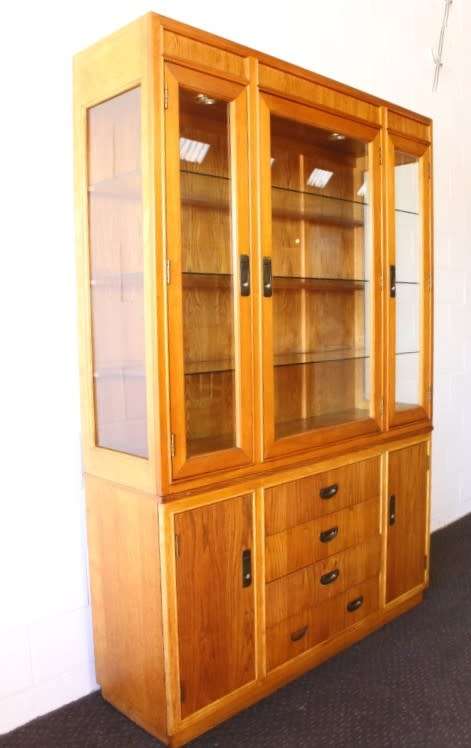 **RS17** A tall 3-door oak display cabinet with lighting, four drawers and two storage cupboards