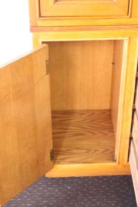 **RS17** A tall 3-door oak display cabinet with lighting, four drawers and two storage cupboards