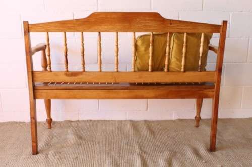A beautifully made solid yellowwood two-seater riempie bench with two gold cushions
