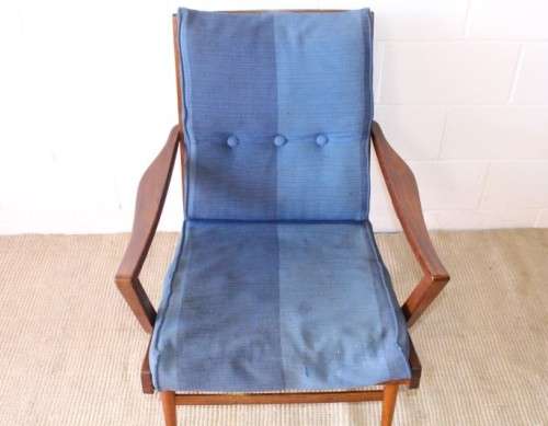 A fabulous mid-century solid teak armchair with sprung seat and backrest and blue fabric cushions