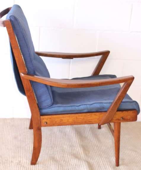 A fabulous mid-century solid teak armchair with sprung seat and backrest and blue fabric cushions