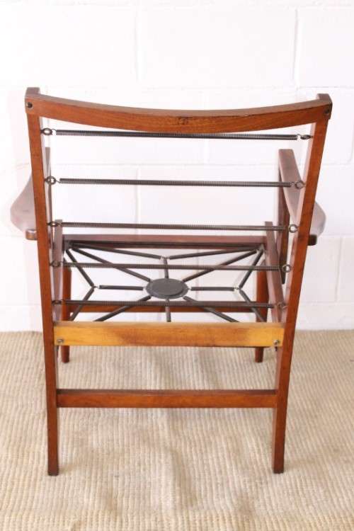 A fabulous mid-century solid teak armchair with sprung seat and backrest and blue fabric cushions