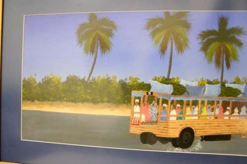 **RS17** A colourful signed and framed behind glass "Robert Nesta" painting "Dala Dala" Zanzibar.