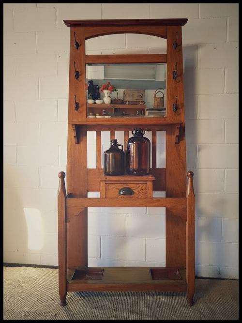 An incredible solid Oak hall stand with a bevelled mirror, drawer and six hooks for hats and coats!