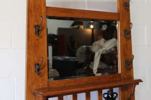 An incredible solid Oak hall stand with a bevelled mirror, drawer and six hooks for hats and coats!