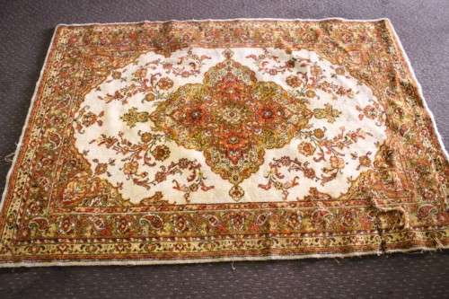 A vintage 189cm x 132cm Persian styled carpet w/ dark greens, marigold yellow, rust & earthy colours