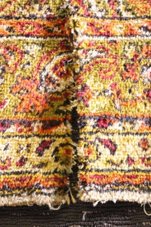 A vintage 189cm x 132cm Persian styled carpet w/ dark greens, marigold yellow, rust & earthy colours