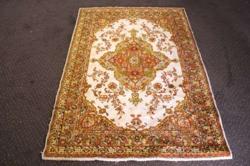 A vintage 189cm x 132cm Persian styled carpet w/ dark greens, marigold yellow, rust & earthy colours