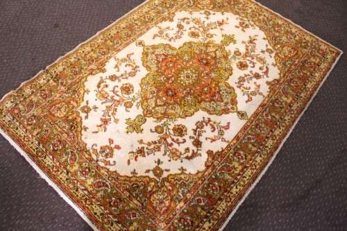 A vintage 189cm x 132cm Persian styled carpet w/ dark greens, marigold yellow, rust & earthy colours