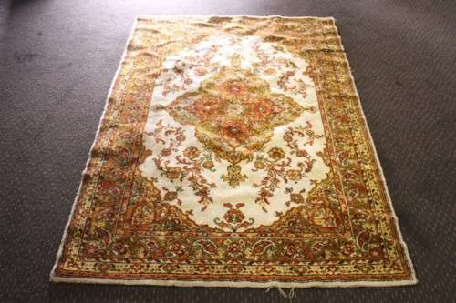 A vintage 189cm x 132cm Persian styled carpet w/ dark greens, marigold yellow, rust & earthy colours