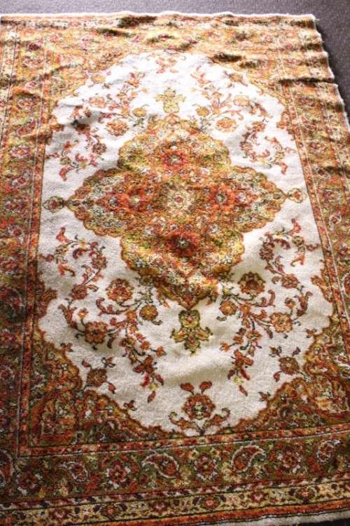A vintage 189cm x 132cm Persian styled carpet w/ dark greens, marigold yellow, rust & earthy colours