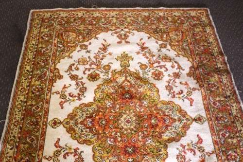A vintage 189cm x 132cm Persian styled carpet w/ dark greens, marigold yellow, rust & earthy colours