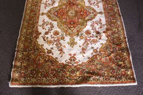 A vintage 189cm x 132cm Persian styled carpet w/ dark greens, marigold yellow, rust & earthy colours
