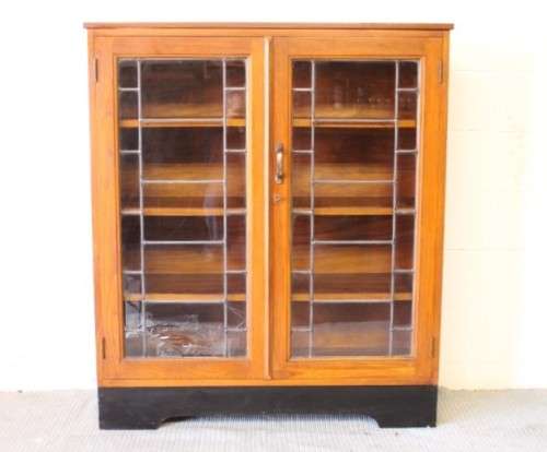 **RS17** A vintage Art Deco 3-fixed shelf double door book cabinet with lead-glass door detailing