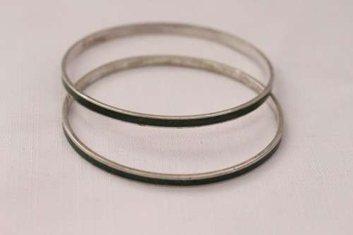 **RS17** A pair of silver metal ladies bangles with a dark green resin inlay band in good condition