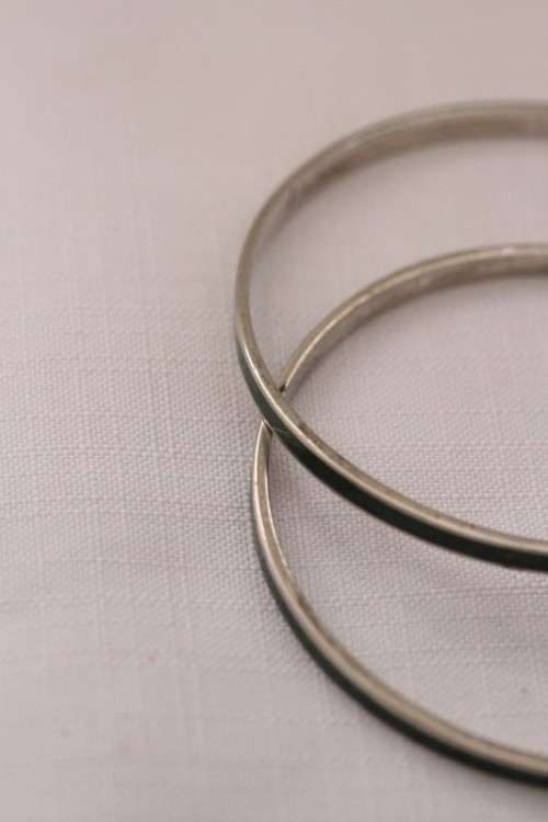 **RS17** A pair of silver metal ladies bangles with a dark green resin inlay band in good condition