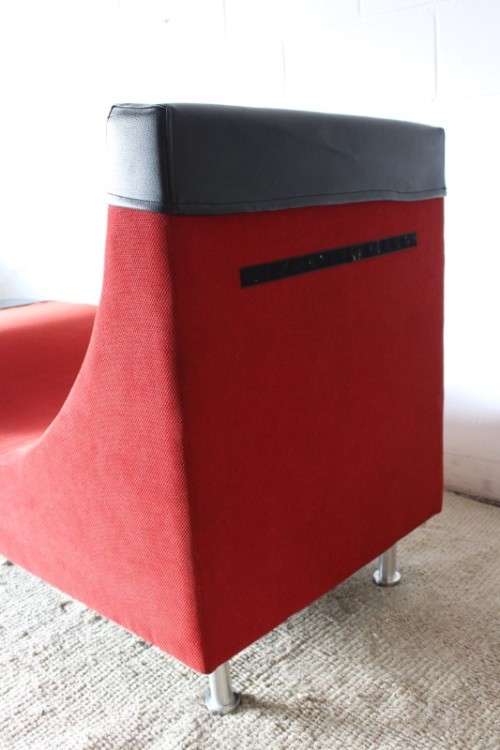 A modern styled black faux leather and red fabric chaise sofa with brushed metal legs