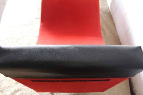A modern styled black faux leather and red fabric chaise sofa with brushed metal legs