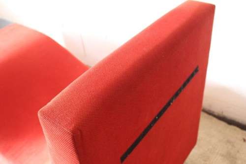 A modern styled black faux leather and red fabric chaise sofa with brushed metal legs