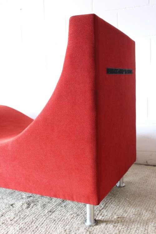 A modern styled black faux leather and red fabric chaise sofa with brushed metal legs