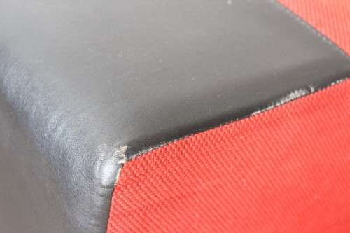 A modern styled black faux leather and red fabric chaise sofa with brushed metal legs