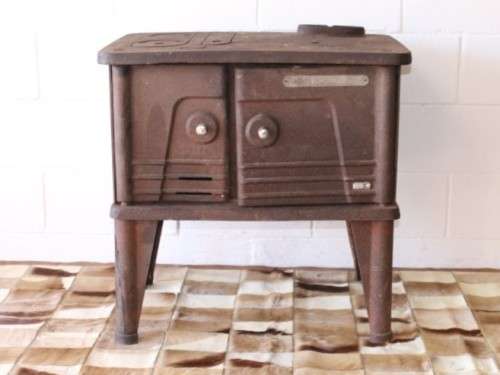 An exceptionally rare antique cast iron two-door coal stove with a chimney vent and removable grates