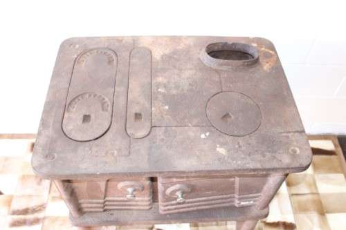 An exceptionally rare antique cast iron two-door coal stove with a chimney vent and removable grates