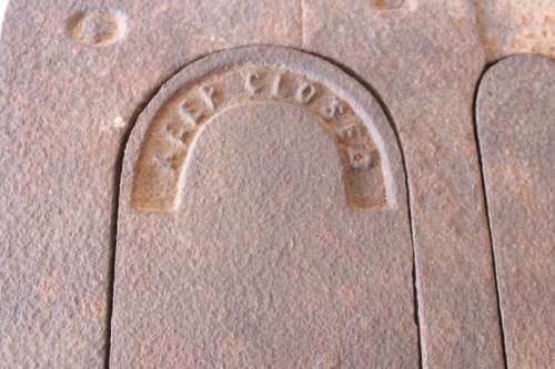 An exceptionally rare antique cast iron two-door coal stove with a chimney vent and removable grates