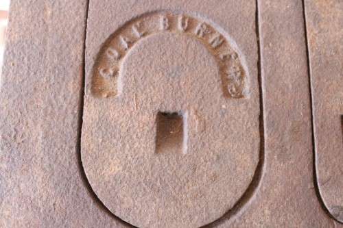 An exceptionally rare antique cast iron two-door coal stove with a chimney vent and removable grates