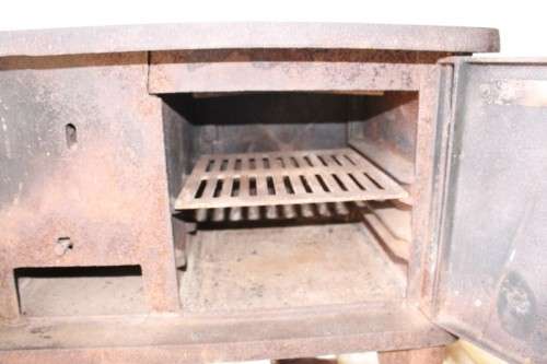An exceptionally rare antique cast iron two-door coal stove with a chimney vent and removable grates