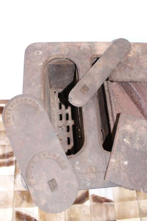 An exceptionally rare antique cast iron two-door coal stove with a chimney vent and removable grates