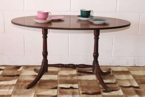 A wonderful vintage Regency style oval coffee table with brass-caped toes and rail inlay detailing